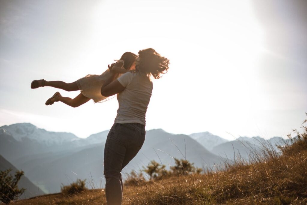 Lea Stecher bindungsorientierte Familienbegleitung spielt mit ihrer kleinen Tochter und wirbelt sie durch die Luft